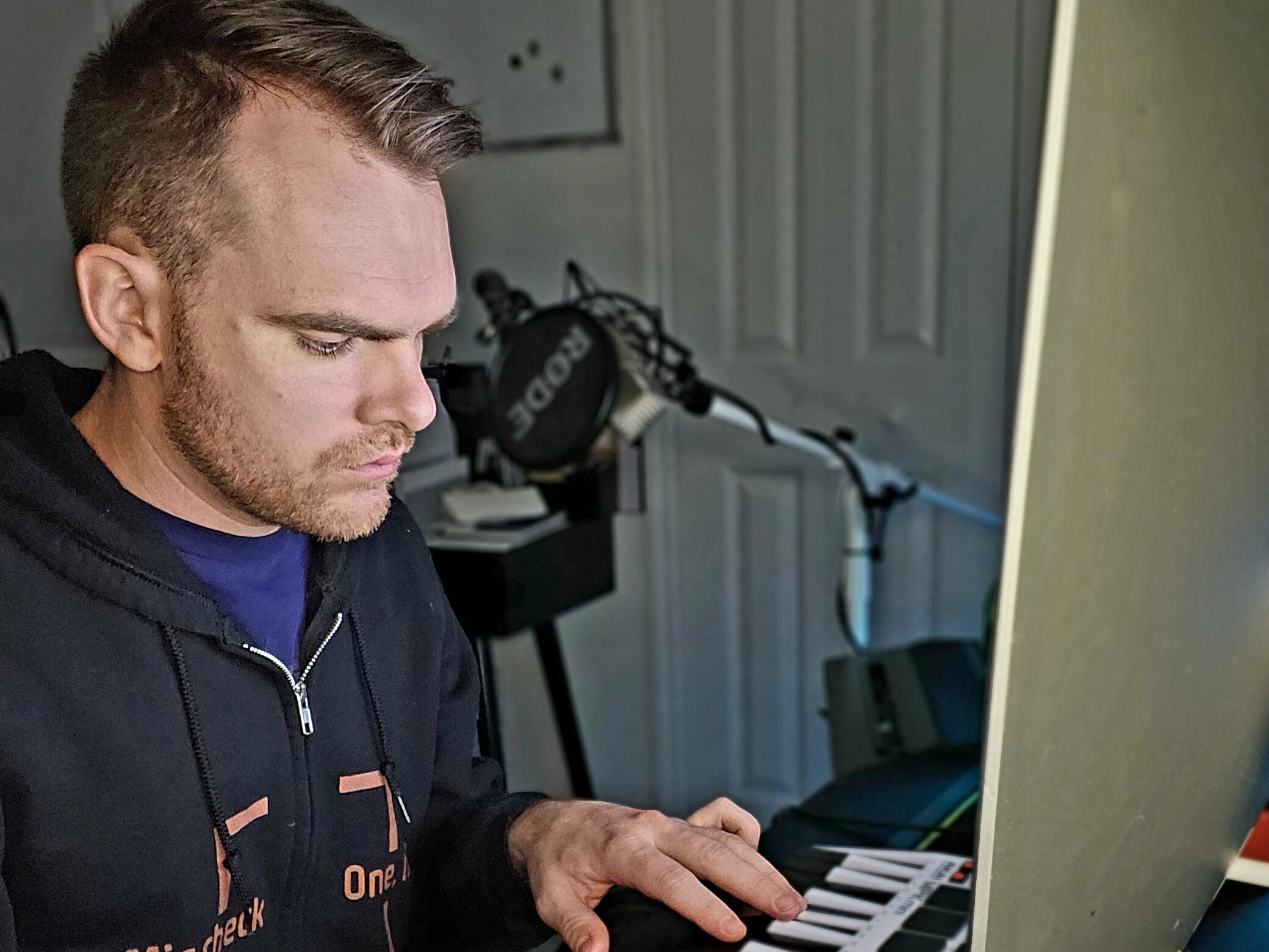 Music producer with his digital keyboard in the studio making beats.